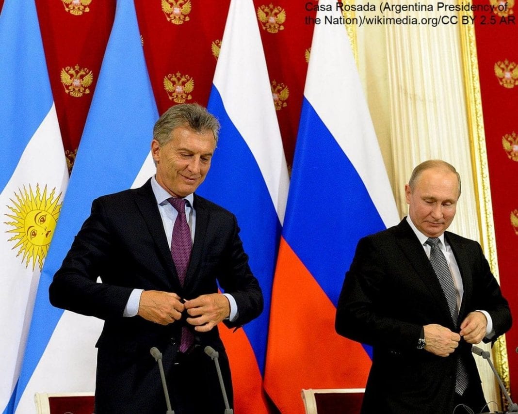 Prezydent Argentyny Mauricio Macri i prezydent Rosji Władimir Putin na tle flag swoich krajów