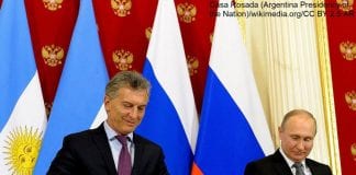 Prezydent Argentyny Mauricio Macri i prezydent Rosji Władimir Putin na tle flag swoich krajów